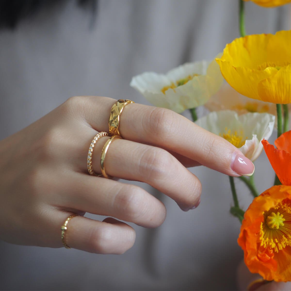woman-holds-flowers-showcasing-gold-rings.jpg